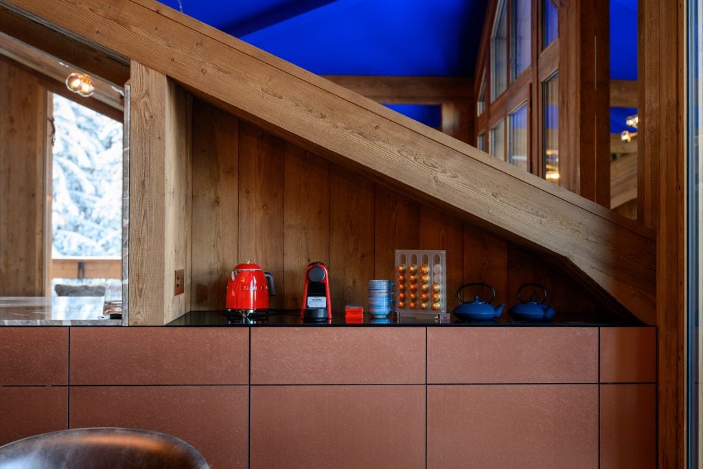 Kitchen counter with Smeg kettle, Nespresso machine, capsule holder, and teapots.