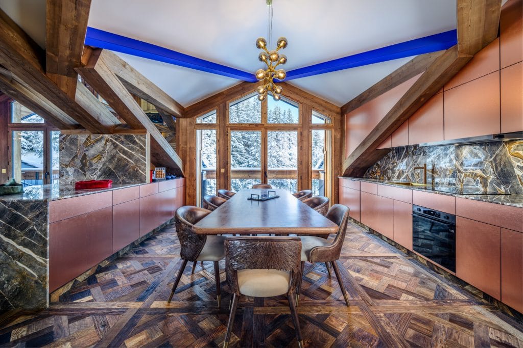 Luxury kitchen and dining room with panoramic forest views in a Courchevel 1650 penthouse.